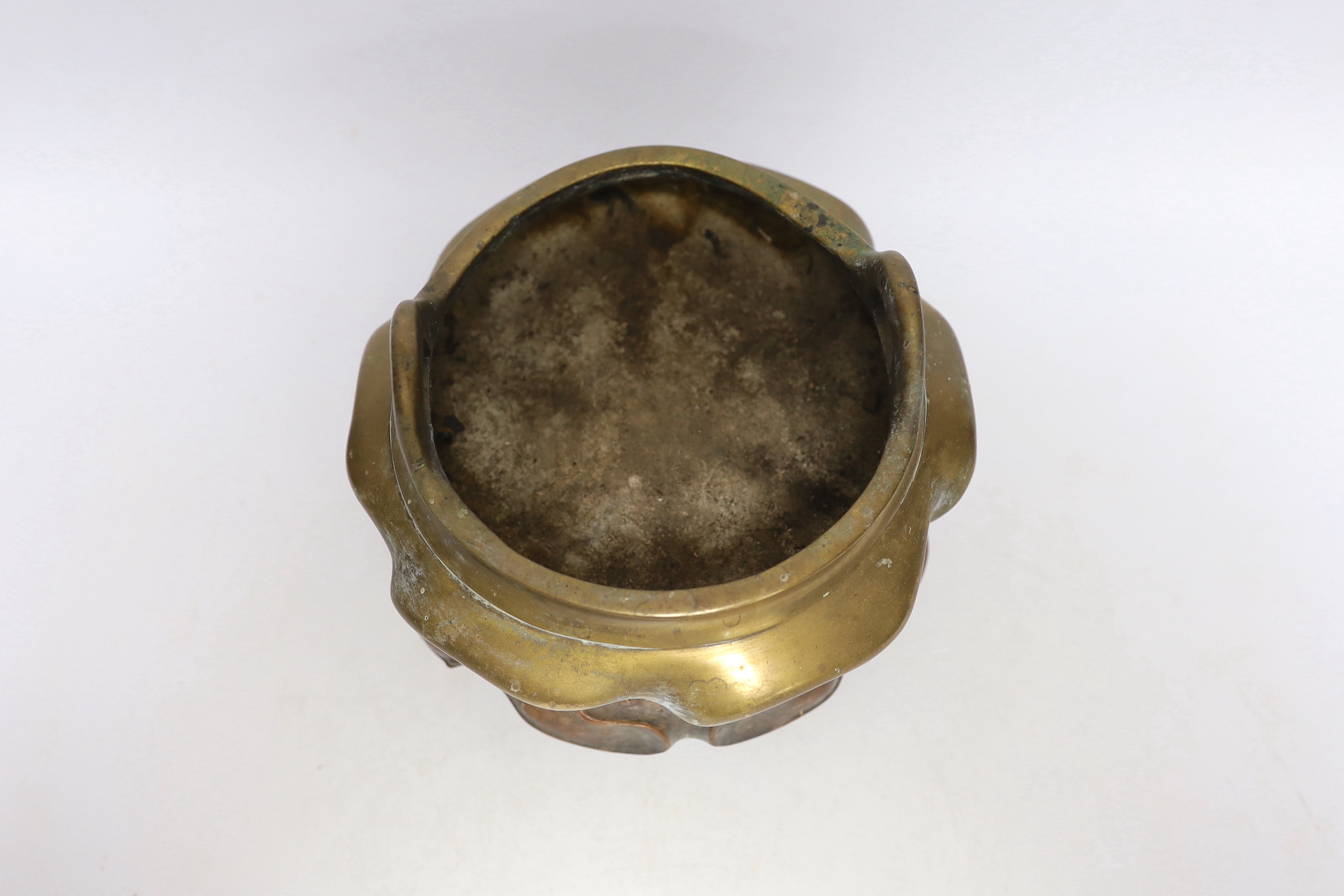 A Chinese bronze tripod censer with twin handles on hardwood stand, censer 19cm wide